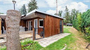 A wooden cabin with a porch, a metal gate, and a clear sky. - Holiday Home 'Ferienhaus 34' with Private Terrace, Shared Garden and Wi-Fi (Zadelsdorf)