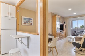 A compact living space with a kitchenette, dining area, and seating area.