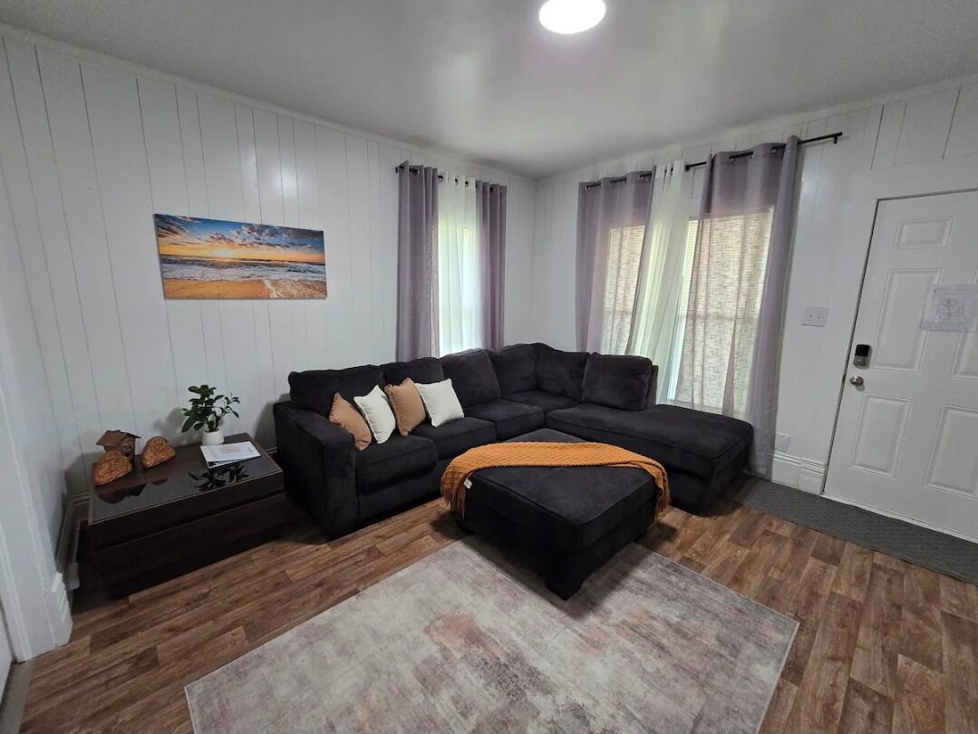 A living room with a sectional sofa, a coffee table, and a rug.
