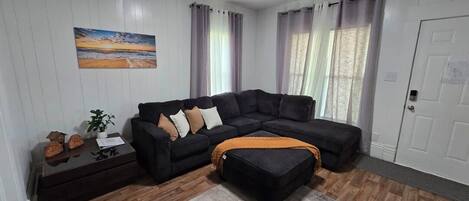 A living room with a sectional sofa, a coffee table, and a rug.