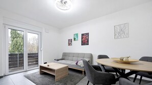Una sala moderna con sofá, mesa de centro y mesa de comedor.