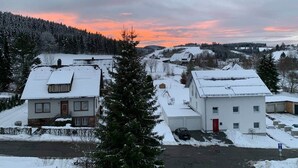 A residential area with houses, a road, and a snowy landscape.