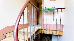 A staircase with ornate metal railings and a checkered floor. - Family & Fun! Pedestrian center near Lake and Ski (Gérardmer)