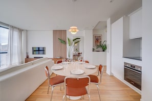 A modern dining area with a round table, chairs, and a large window. - Apartment with parking in the heart of Chartrons (Bordeaux)
