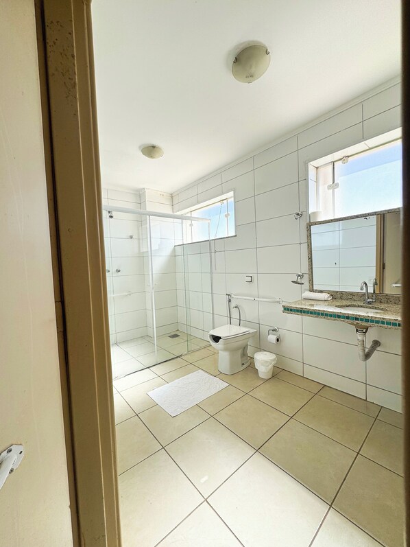 A bathroom with a toilet, sink, and shower. - Copaiba Palace Hotel (Bauru)