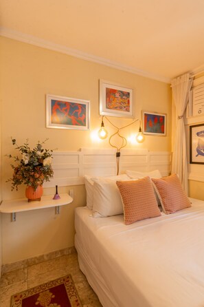 A bedroom with a bed, a nightstand, a lamp, and wall art. - Boutique Studio 4 Minutes From Copacabana Beach Jc702b (Rio de Janeiro)