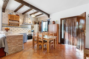 Cozinha com mobiliário de madeira, painel de azulejos e porta de madeira.
