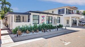 Un edificio moderno su due piani con ampie finestre, un portico coperto e un giardino antistante curato.