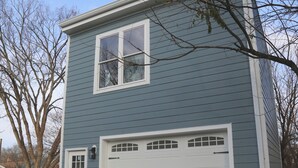 A two-story house with a garage, a front door, and a window. - Charming DC Carriage House: Perfect for Couples, Small Families Weekend Trips (Washington DC)