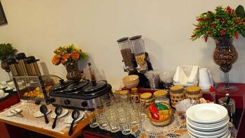 A buffet setup with various food items, utensils, and decorative elements.