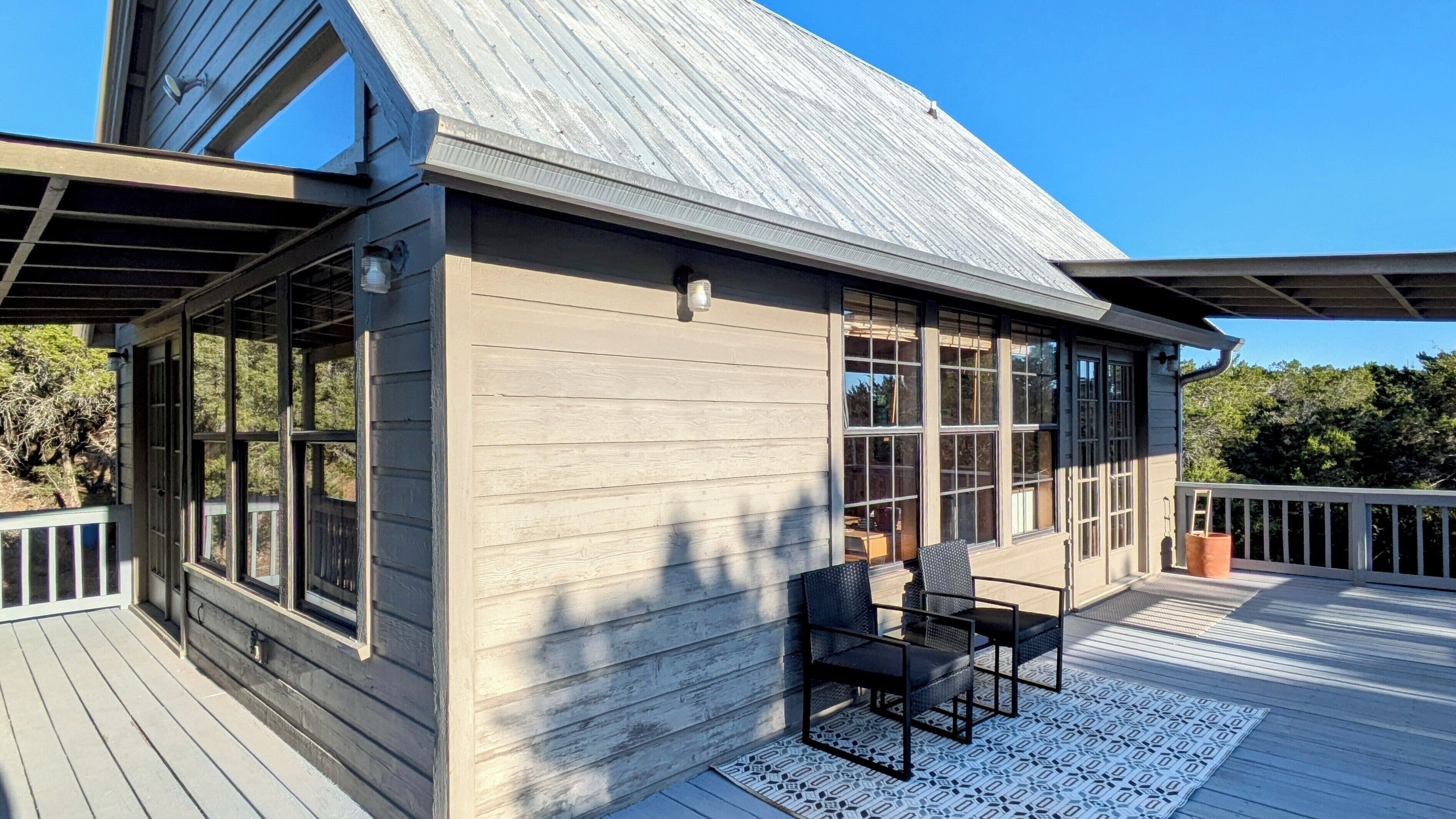 A wooden deck with a built-in seating area and large windows.