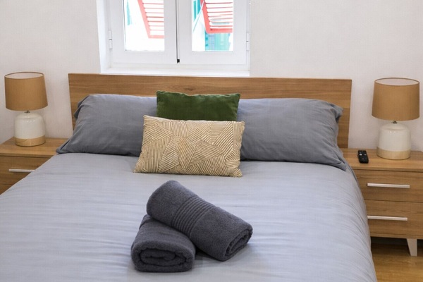 Bedroom with double bed, fresh linens, and bedside lighting