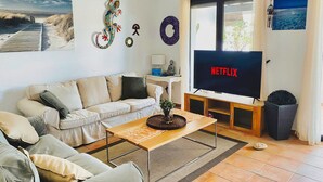 A living room with a sofa, coffee table, TV, and decorative items.