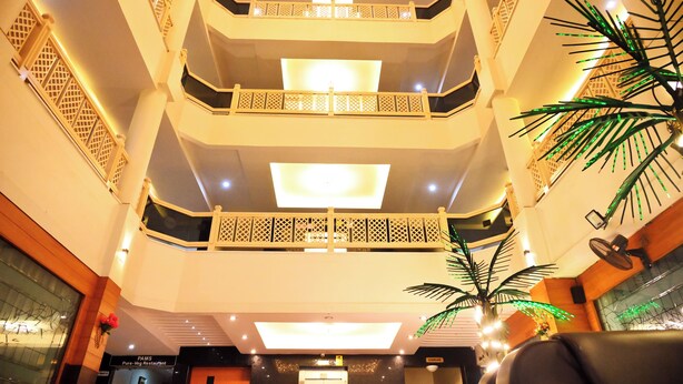 A multi-level atrium with balconies, a reception area, and a Pure-Veg Restaurant. - Hotel pams (Mayiladuthurai)