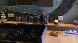 Eine Küche mit Gaskochfeld, Dunstabzugshaube und einer Wand mit Steinverkleidung.