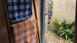 Ein Badezimmer mit Fenster, Handtuchhalter und Toilettenpapierhalter.