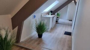 Une cuisine moderne dotée d’un îlot central, d’appareils électroménagers intégrés et d’un petit coin salon.