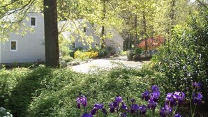 A residential area with houses, a garden with purple flowers, and a pathway. - Chalet 7 - 8P-Pool -100m Black Frame (Saumur)