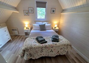 A bedroom with a bed, two bedside tables, a window, and a dresser. - Chalet 8 - 8P - Piscine & Parc , 100m Cadre Noir (Saumur)