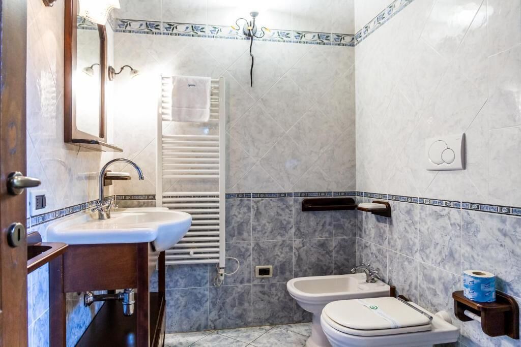 Un bany amb un rentapans, dues vàteres, un para-tovellons i una dutxa.