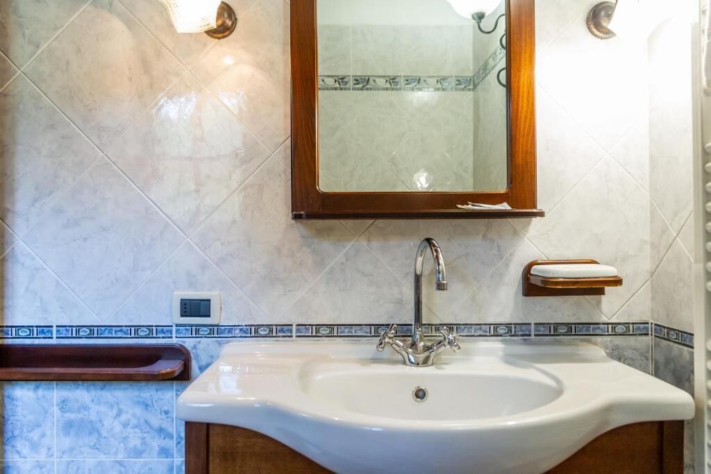 Ein Badezimmer mit Waschbecken, Spiegel und Handtuchhalter.