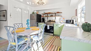 A kitchen with a dining table, chairs, and a refrigerator. - Pet-Friendly Crystal River Retreat - Near Manatees & Golf (Crystal River)
