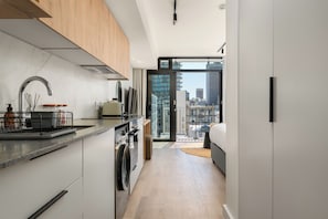 Una cocina moderna con horno empotrado, un fregadero y una ventana con vistas a la ciudad.