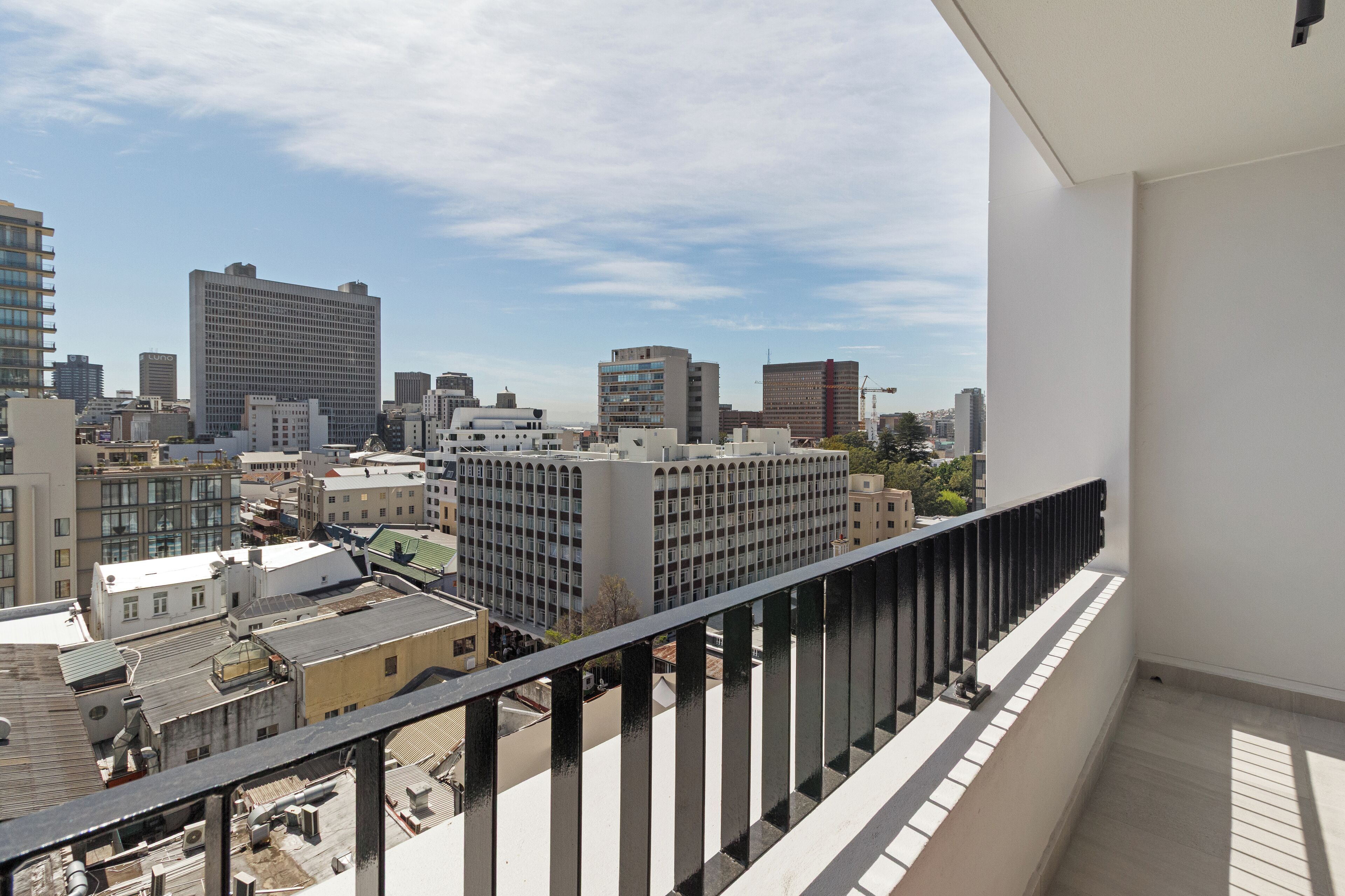 Un immeuble de grande hauteur doté d’un balcon donnant sur un paysage urbain.