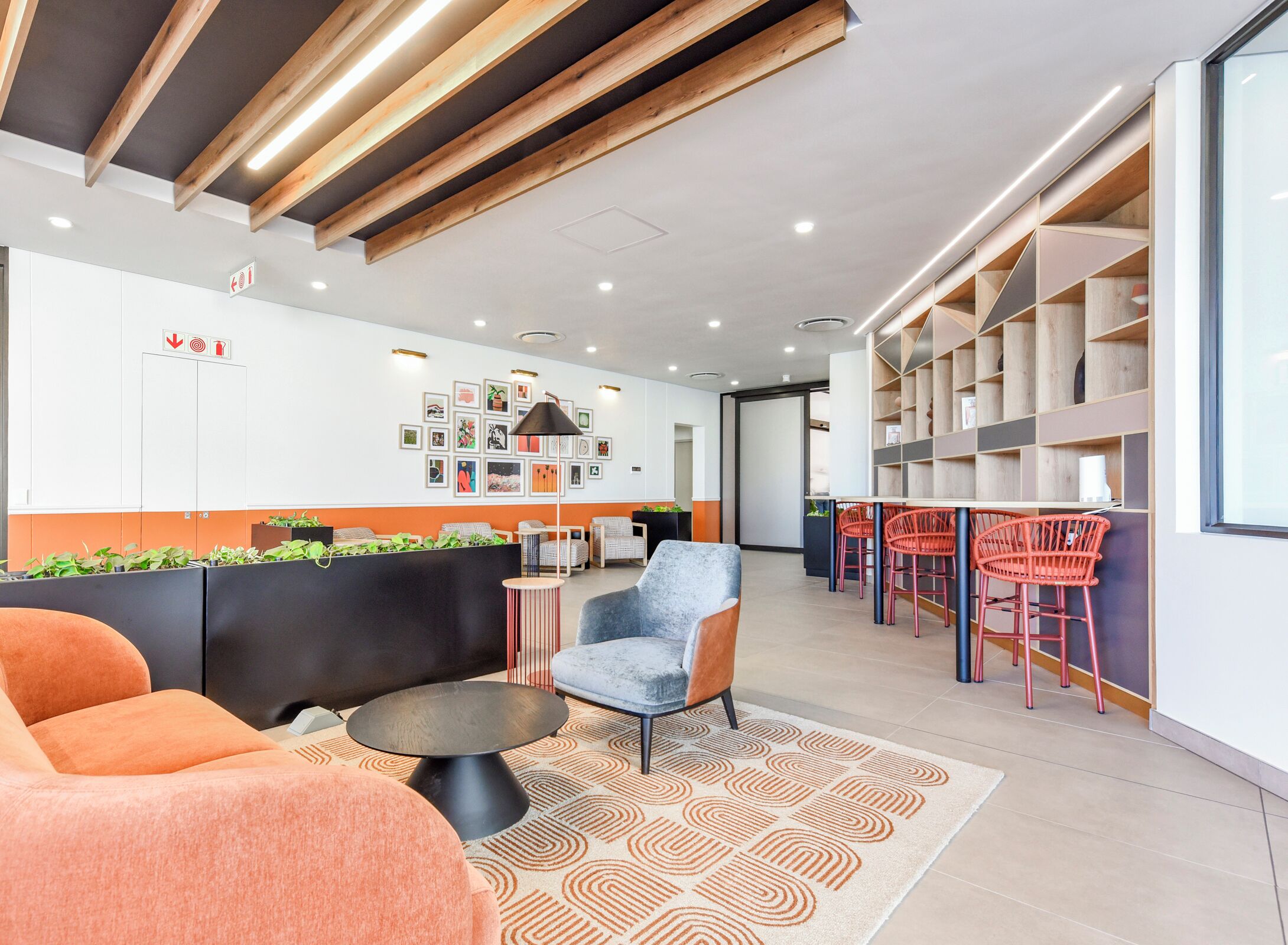 A modern reception area with a sofa, chairs, a coffee table, and a patterned rug.