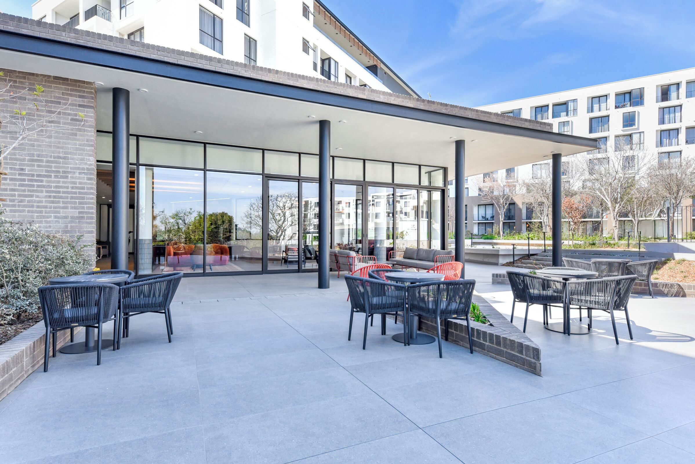 An outdoor patio area with tables and chairs, a covered seating area, and a view of the surrounding buildings.