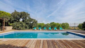 A swimming pool with wooden deck, surrounded by trees and a clear sky. - Casa de Campo Vale do Asno – Bungalow '2' with Shared Pool, Wi-Fi & Air Conditioning (Castro Marim)