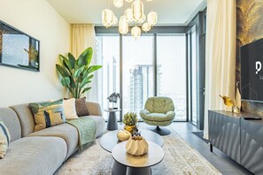 Un salon moderne avec un canapé, des fauteuils, une table basse et un téléviseur.