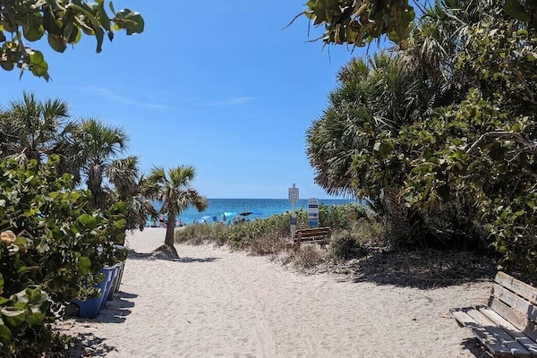 Ranta lähistöllä, aurinkotuoleja, rantapyyhkeitä