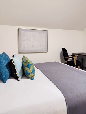 Une chambre d’hôtel avec un lit, un bureau et une chaise.