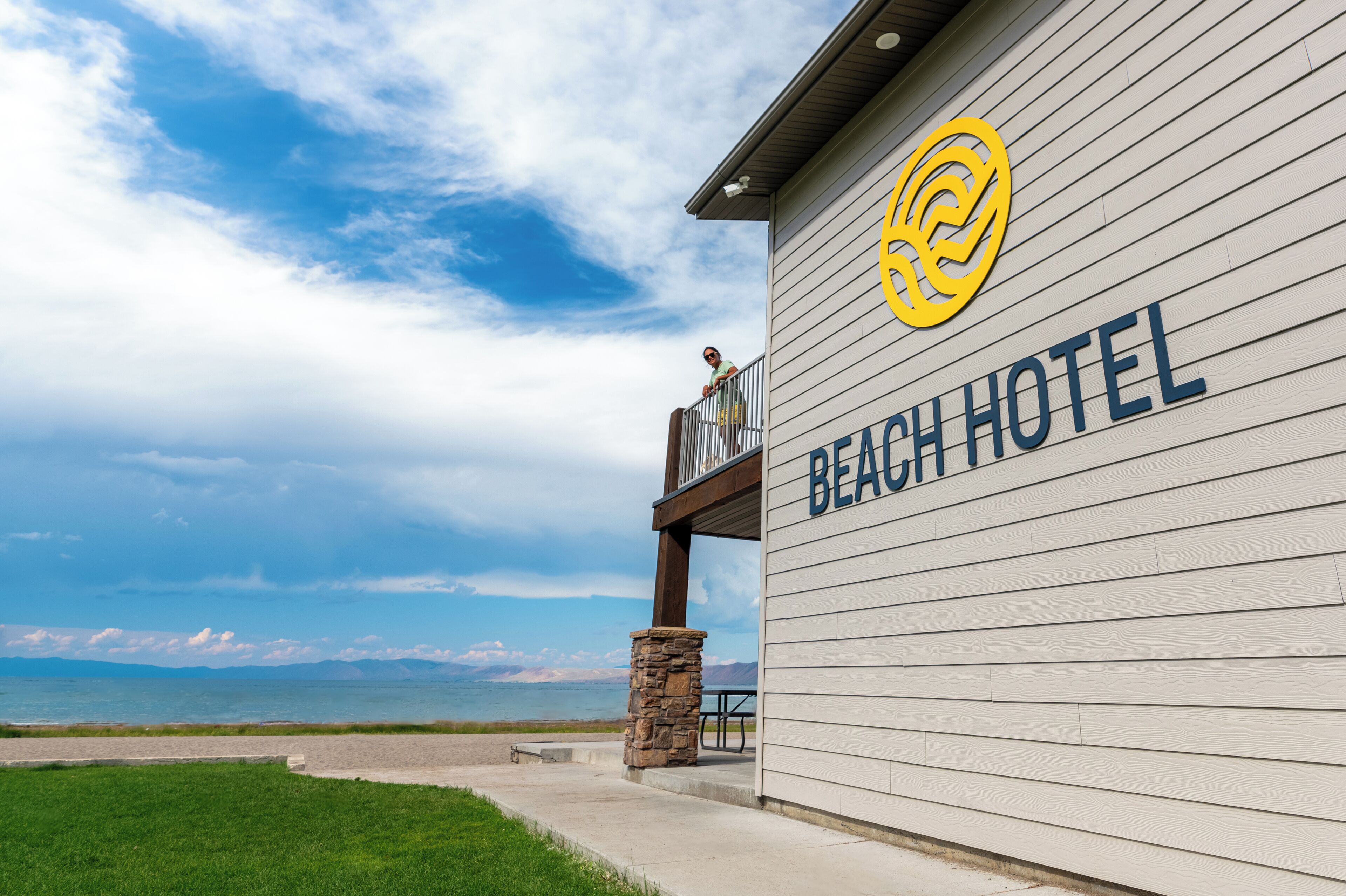 A beach hotel with a view of the ocean and mountains.