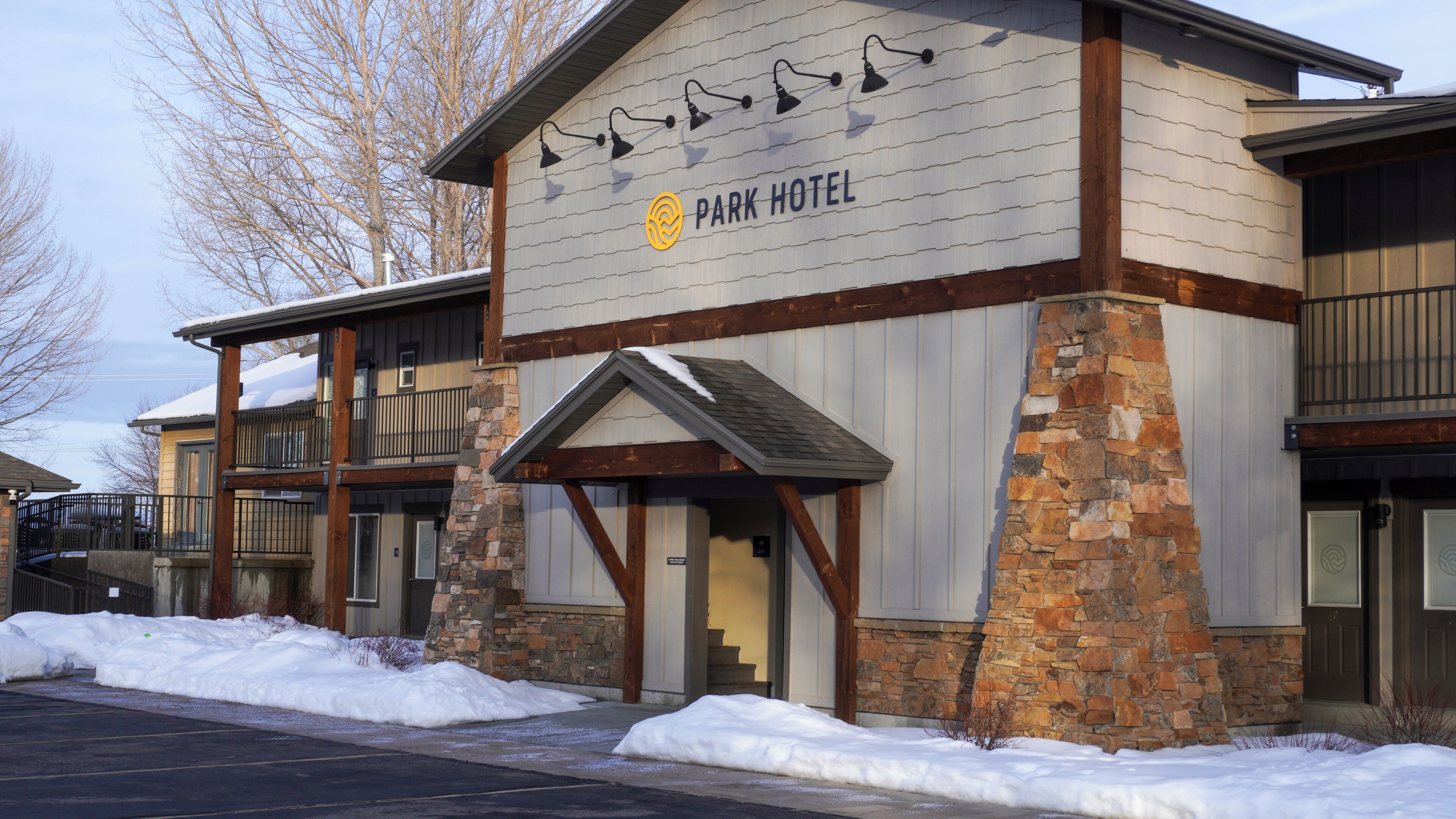 A hotel with a stone facade, wooden beams, and a sign reading "Park Hotel".