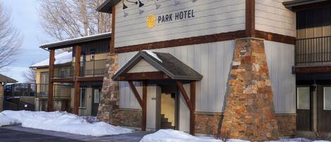 A hotel with a stone facade, wooden beams, and a sign reading "Park Hotel".