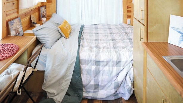 A cozy wooden cabin bedroom with a bed, a desk, and a window with curtains. - Tiny Home Retreat with Bunnies, Chickens & a Goat near Gulf Coast Beach Navarre (Navarre)
