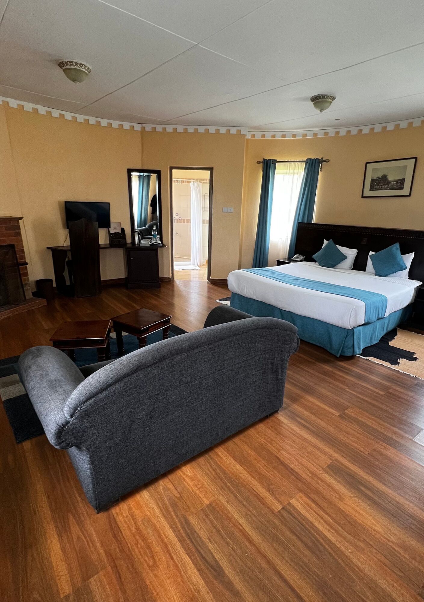 Ein Hotelzimmer mit einem Bett, einem Schreibtisch, einem Sessel, einem Fernseher und einem Kamin.
