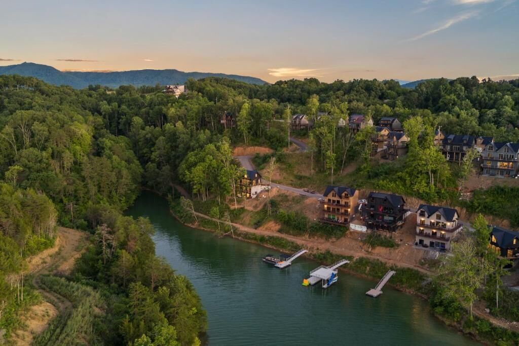 A riverside property with multiple houses, a dock, and a boat.