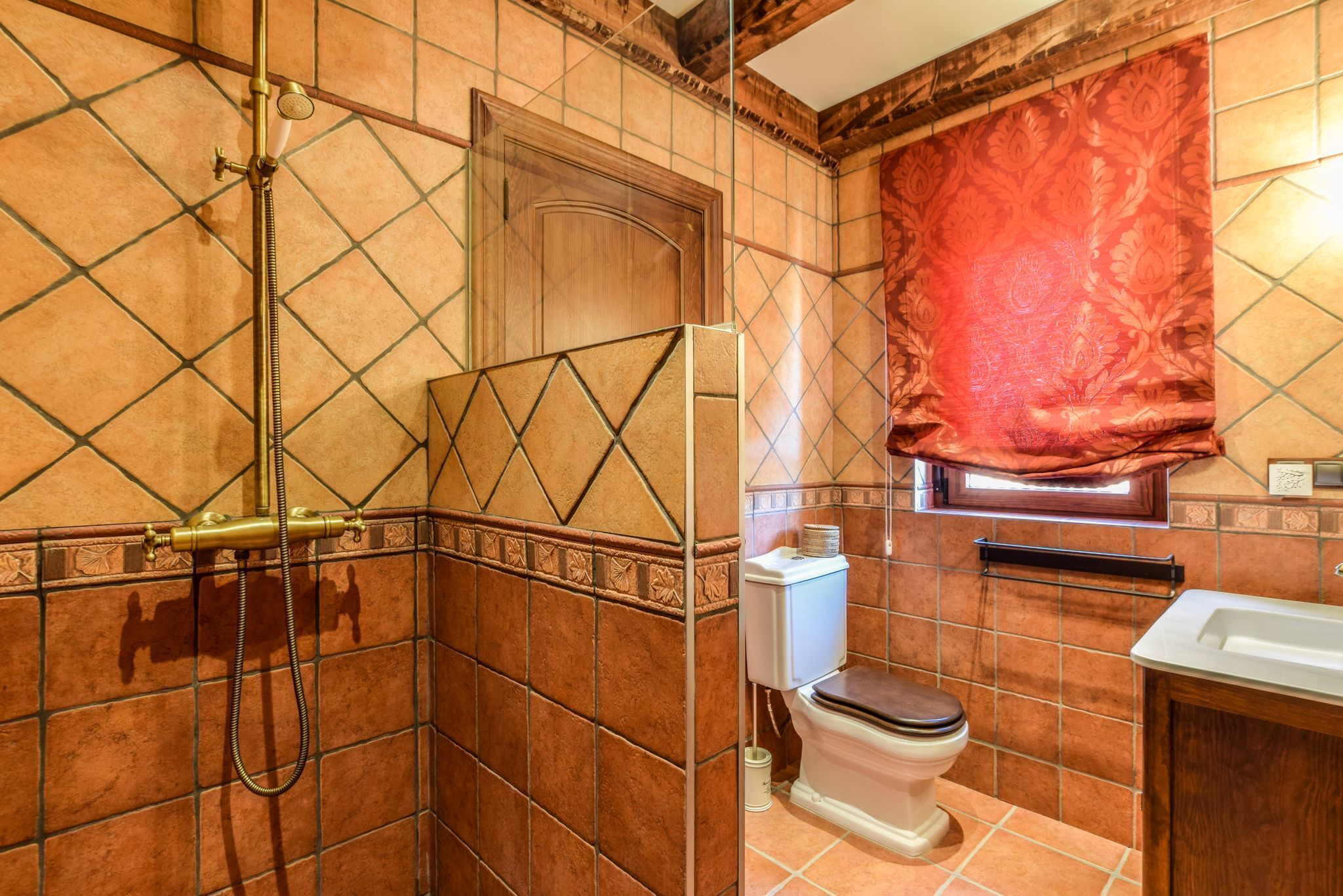 A bathroom with a shower, toilet, and sink.