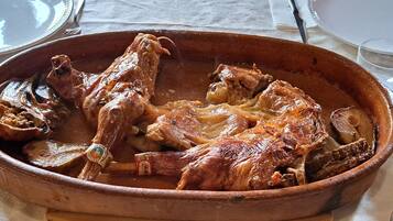 Un plato grande de cerámica con pollo asado sobre una mesa.