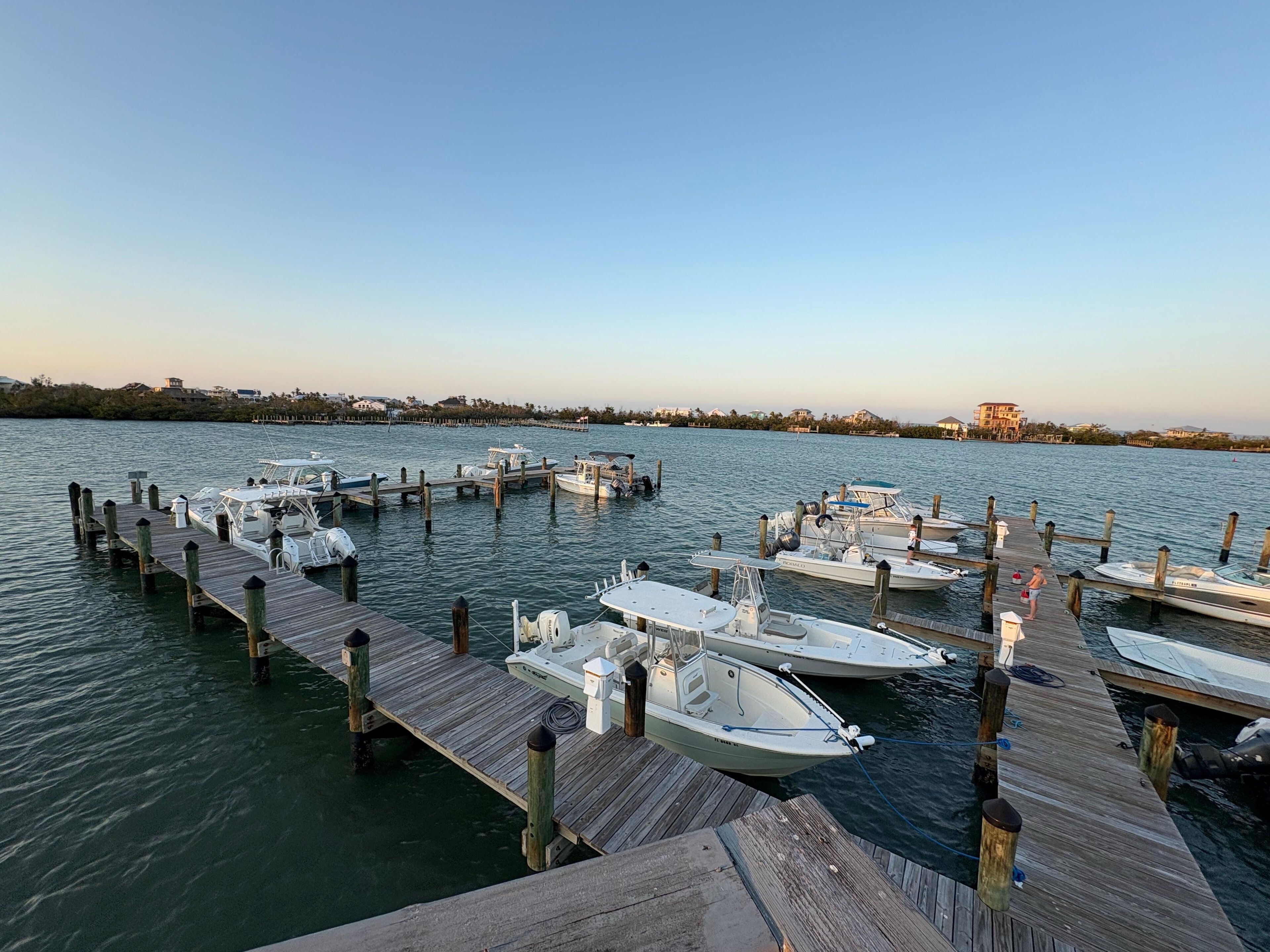 A marina with several boats docked at wooden piers.