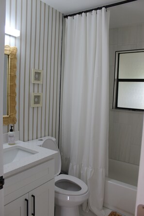 Een douche, handdoeken, zeep, toiletpapier