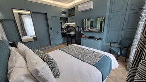 A modern hotel room with a large bed, a desk, a mirror, and a television. - Loft-Executive-Garden view-Private Bathroom (Troyes)