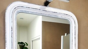 A bathroom with a white-framed mirror, a towel rack with folded towels, and a plant. - Loft-Executive-Garden view-Private Bathroom (Troyes)