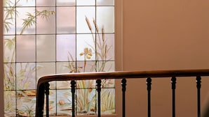 A staircase with a railing and a stained glass window with floral designs. - Apartment-Luxury-Private Bathroom-Garden view-Rdc A (Troyes)