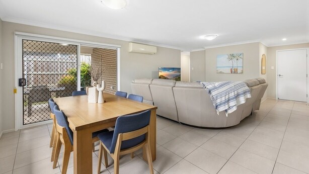 A modern living room with a dining area, a sofa, and a painting on the wall. - Middle Ridge Retreat – Walk to Shops & Parks! (Middle Ridge)