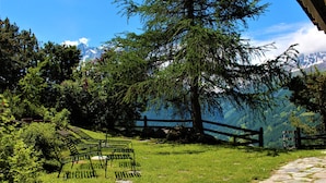 A grassy area with a stone pathway, a wooden fence, and a bench. - Melody - Joli 2 pièces | La Sage (La Sage)