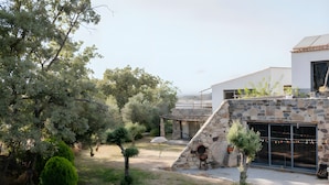 Un bâtiment en pierre doté d’un espace extérieur couvert, d’un barbecue et offrant une vue sur le paysage environnant.